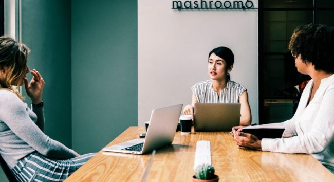 pessoas sentadas em uma mesa discutindo ações de endomarketing