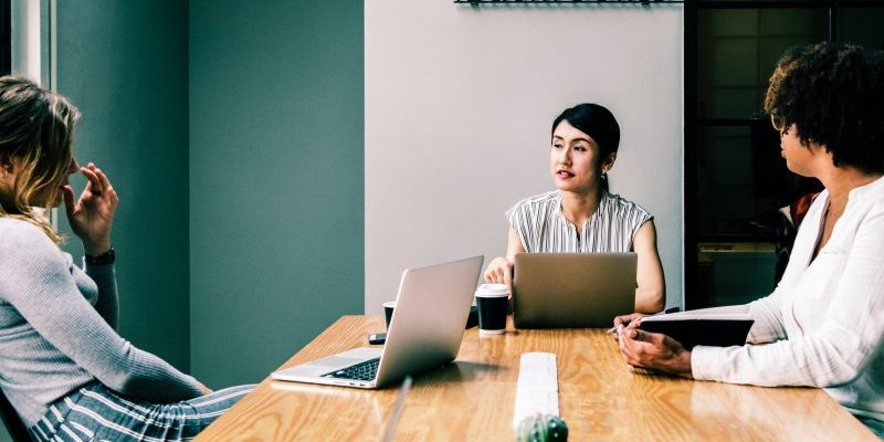 pessoas sentadas em uma mesa discutindo ações de endomarketing