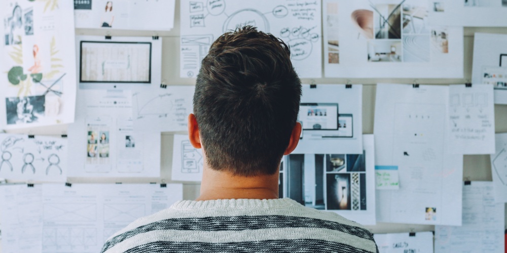 pessoa_olhando_para_mural_criativo Pessoa analisando murar de ideias