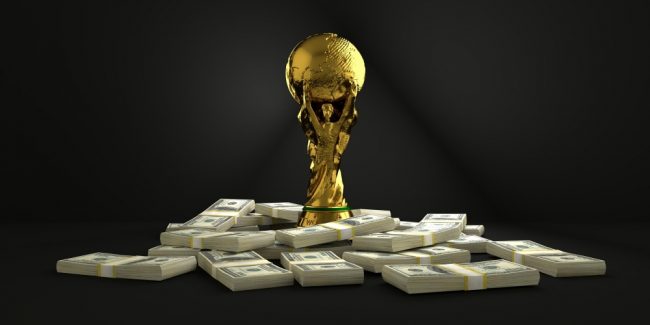 Taça da copa do mundo sobre maços de dinheiro
