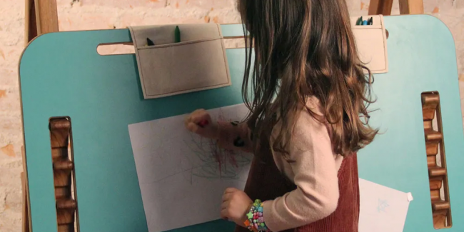 Criança utilizando Mesa Compasso Infantil Regulável como lousa