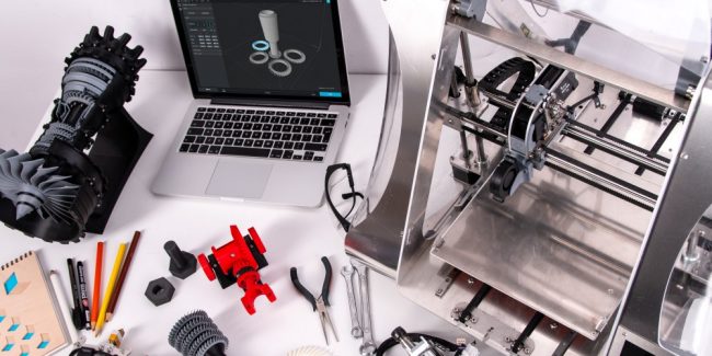 Revolução 3D - impressora 3D, notebook e impressões 3D sobre a mesa